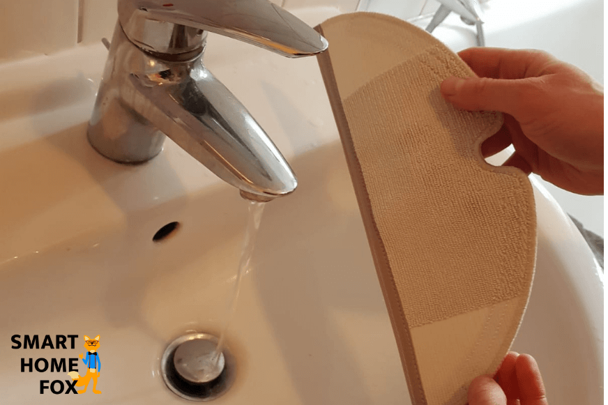 Dampening the mop of a vacuum-mop robot with water before mopping